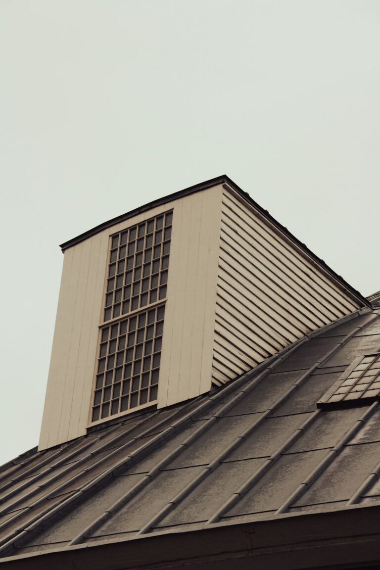Attic with visible insulation, soffit vents, roof framing, and airflow moving toward a ridge vent.